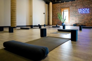 Mats and yoga blocks are carefully laid out in the Moon Yoga studio, ready for a class. 